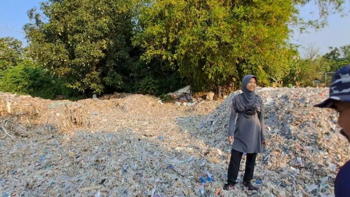 Azzahra amid a pile of plastic waste around a paper factory in East Java, Indonesia. 