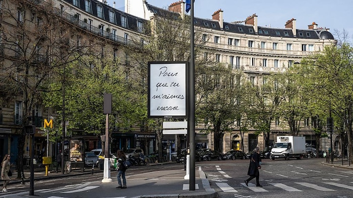 Une affiche est dans une rue de Paris. 