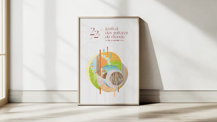 L'affiche du Festival des guitares du monde encadrée et posée contre un mur.