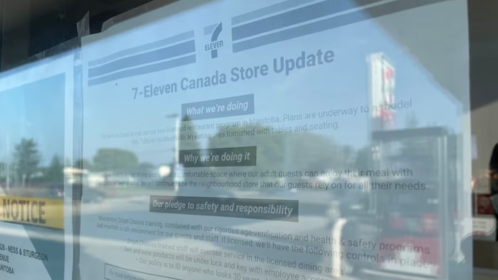 Une affiche de la chaîne de dépanneurs 7-Eleven apposée à la vitre du commerce.
