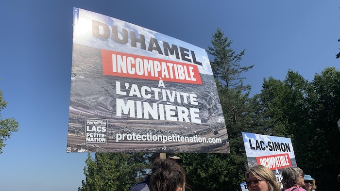 Des affiches sur lesquelles il est écrit « Duhamel incompatible à l'activité minière » et « Lac-Simon incompatible à l'activité minière ».