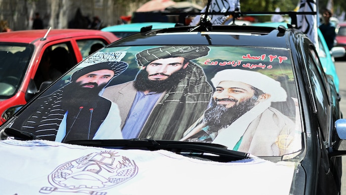 Une voiture arborant une affiche composée de photographies d’Oussama ben Laden, le chef d’Al-Qaïda tué, du défunt chef des talibans, le mollah Omar, et du ministre afghan de l’Intérieur, Sirajuddin Haqqani.