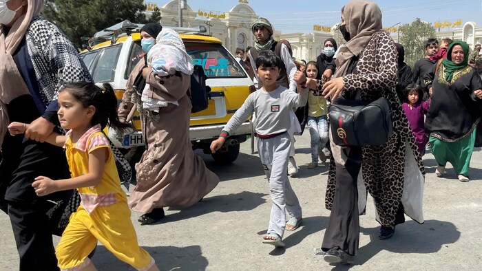 Women with their children try to get inside Hamid Karzai International Airport in Kabul, Afghanistan on August 16, 2021.
