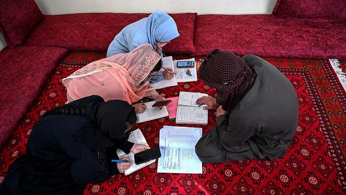 Des filles afghanes suivant un cours dispensé par leur père à leur domicile.