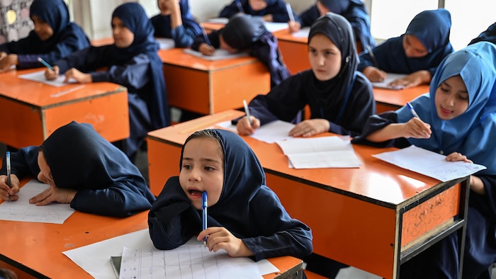 Cette photo prise le 21 juillet 2026 montre des fillettes afghanes passant leurs examens de mi-semestre dans une école primaire de Kaboul.