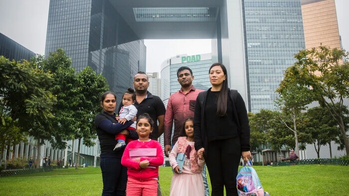 The group of asylum seekers who helped shelter Edward Snowden are seen in Hong Kong in February, 2017. They are: Kellapatha, third left, Nonis, left, Dinath and Sethumdi, with their parents. Plus, Sri Lankan refugee Ajith Pushpakumara, third right, and Filipino refugee Vanessa Rodel, right, with her daughter Keana. 