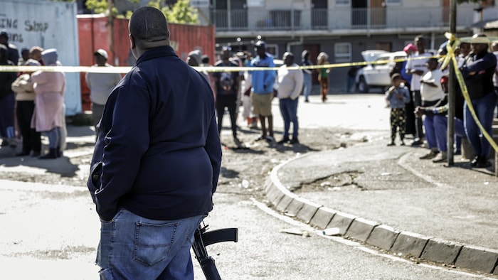 Un membre des services de police sud-africains (SAPS) monte la garde à Somerset West près d'un lieu où des hommes armés ont tué au moins 27 personnes.