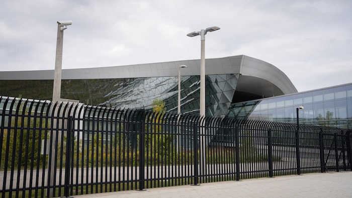 A modern and glazed building behind an iron fence. budget canadian cyberespionage agency almost budget canadian cyberespionage agency almost new