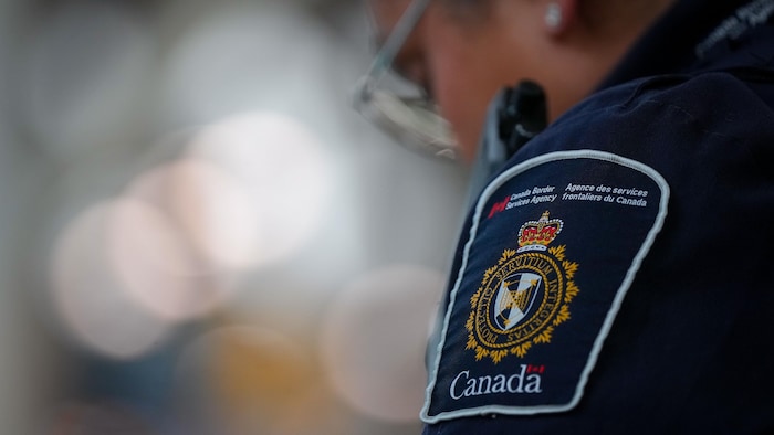 On aperçoit un insigne de l'Agence des services frontaliers du Canada sur l'uniforme d'un agent de l'ASFC.