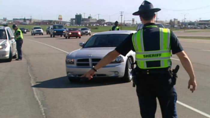 Patrouilleur routier indiquant à une voiture de s'arrêter sur le bord de la route.