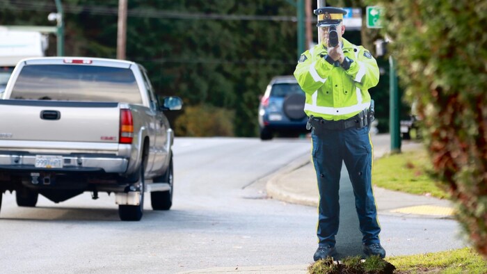 Un réplique en deux dimensions d'un policier pointant un radar est installée sur le coin d'une rue. 