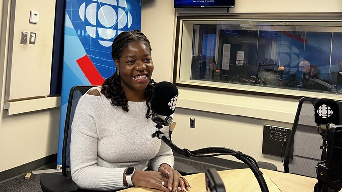 Une jeune femme en entrevue dans un studio de radio.