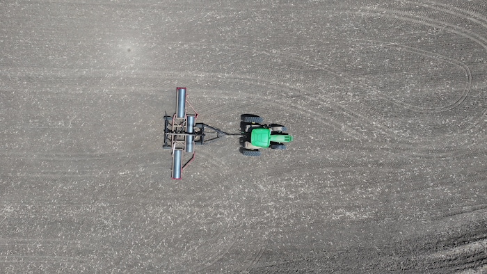 Photos aériennes (par drone) d'un tracteur dans un champ.