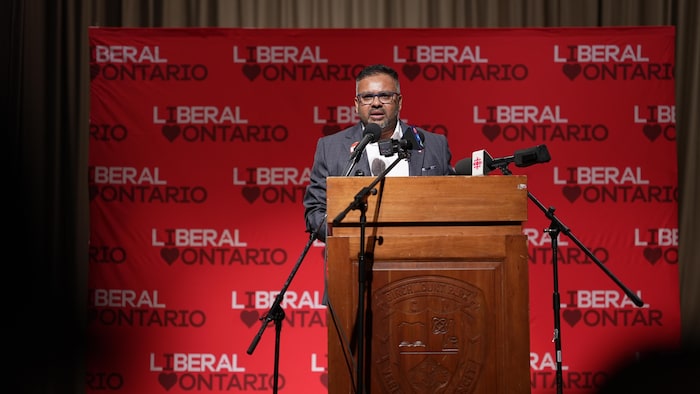 Ahsanul Hafiz debout derrière un lutrin