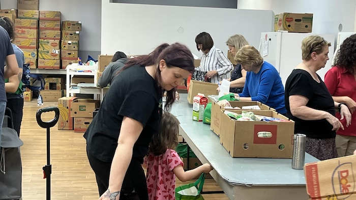 Une mère et sa fille attendent de recevoir leurs biens alimentaires à la Société Saint-Vincent-de-Paul de Québec.