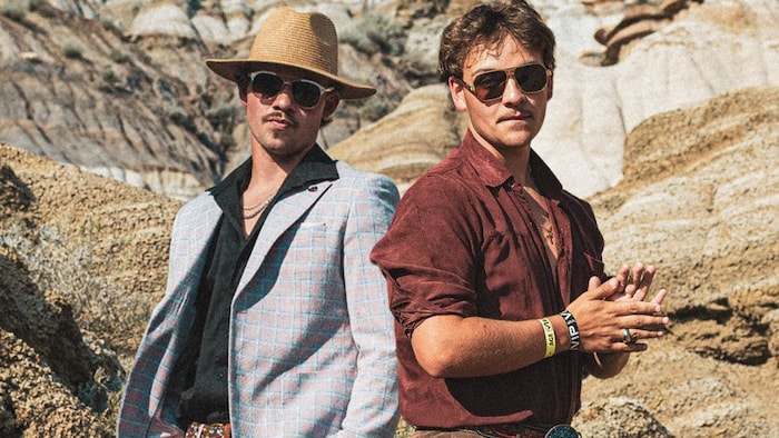Aiden et Logan Edwards, côte à côte sur une colline, regardant la caméra.
