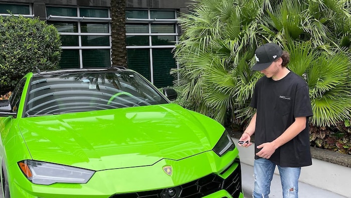 Aiden Pleterski près d'une Lamborghini.