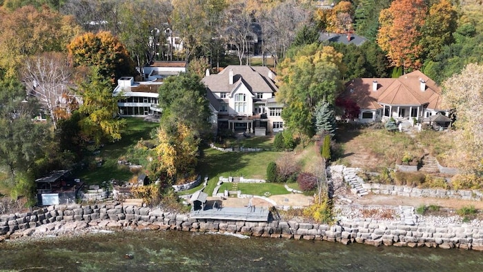 Une immense maison sur le bord d'un lac.