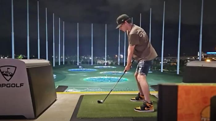 Aiden Pleterski s'apprête à frapper une balle de golf.