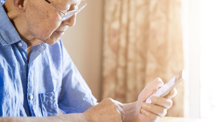 Un homme âgé utilise un cellulaire.