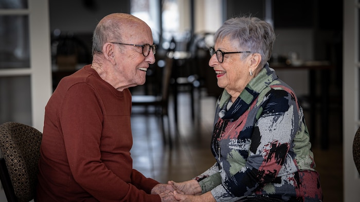 Gratien Cossette et Lise Carignan se sourient en se tenant les mains. 