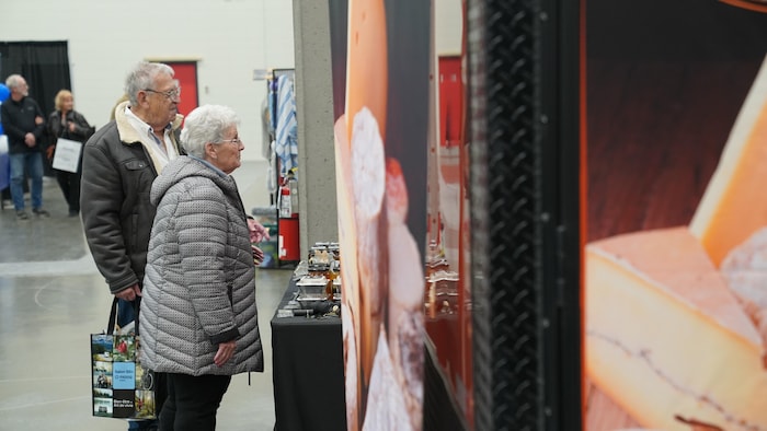 Des visiteurs consultent un kiosque. 