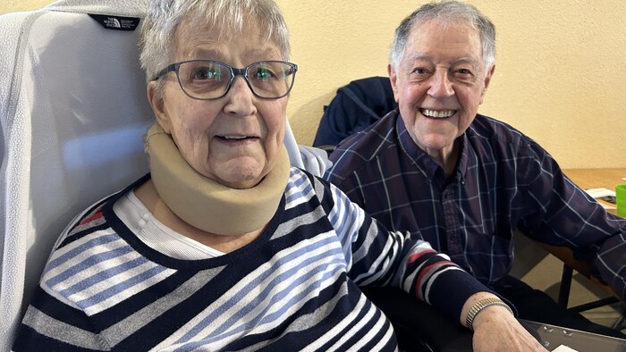 Les deux aînés sourit à la caméra, assis à table.