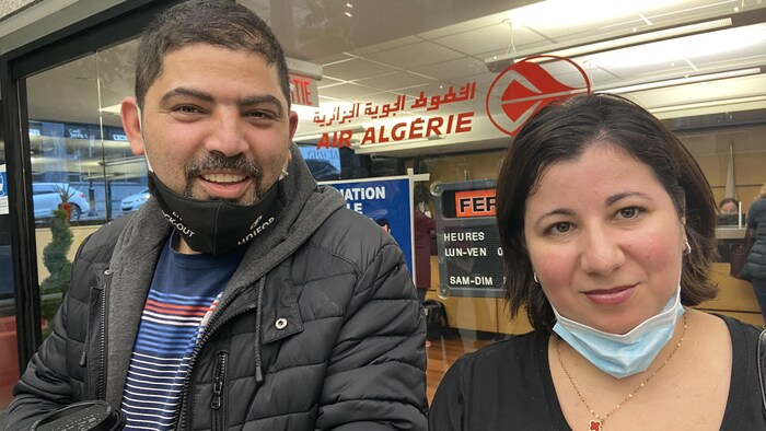 رجل وامرأة يقفان أمام واجهة زجاجية لوكالة.