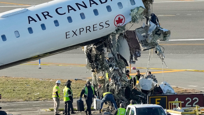 Des enquêteurs près de l'appareil au cockpit arraché.