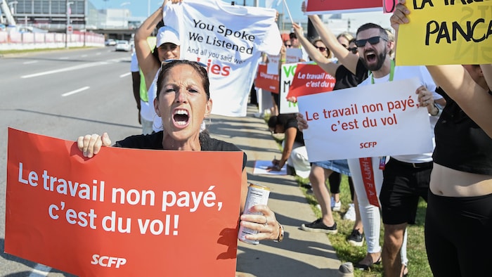 Des agents de bord d'Air Canada font la grève devant l'aéroport international Montréal-Trudeau.