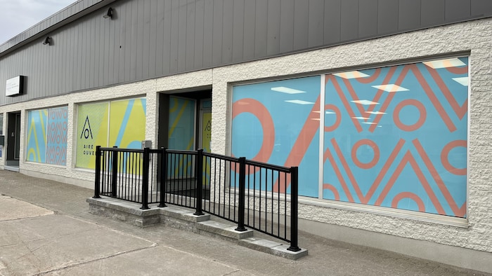 Une façade avec des vitres décorées de formes colorées.