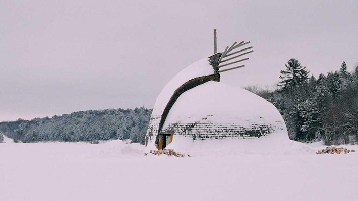 Une habitation autochtone ronde au coeur de l'hiver.