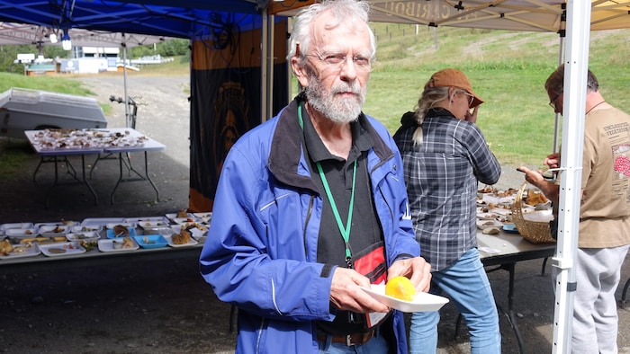 Portrait de Alain Carle devant une table de champignons.