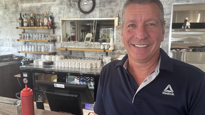 Un homme devant un bar.