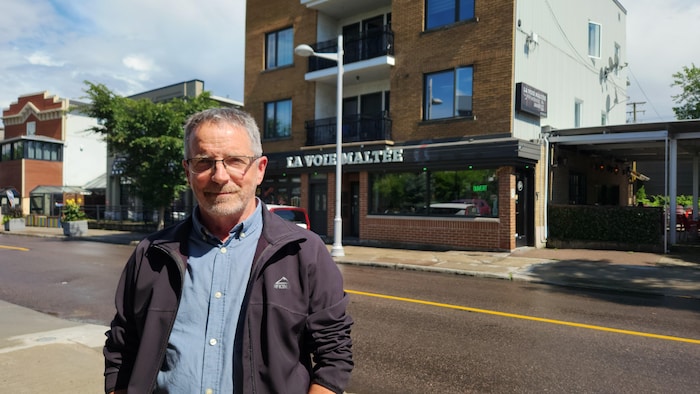 Portrait d'Alain Doré devant la Voie Maltée sur la rue Saint-Dominique à Jonquière. Selon lui, c'est une triste nouvelle pour la rue Saint-Dominique mais une opportunité pour la Voie Maltée. 