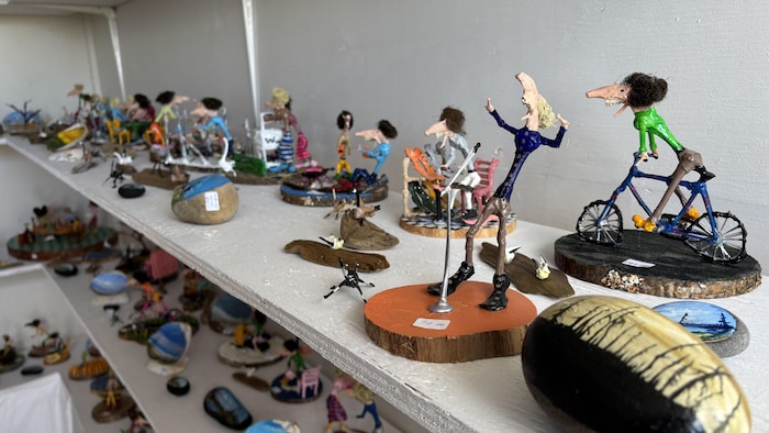 Vue en perspective d'une étagère remplie de petites sculptures d'art populaire représentant des scènes du quotidien.