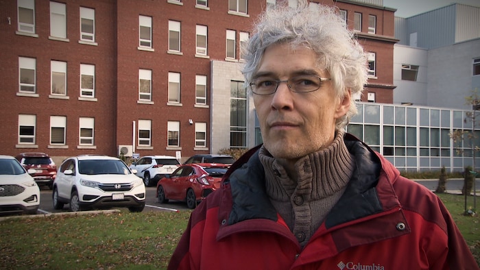Le professeur Alain Patoine devant le bâtiment d'accueil de l'Université de Moncton, campus de Shippagan.