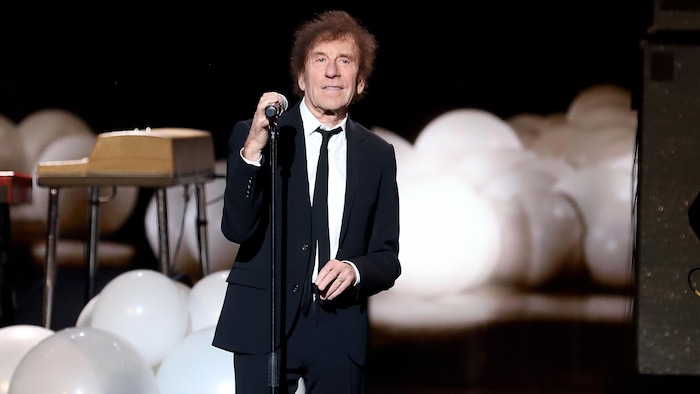 L'homme chante sur scène.