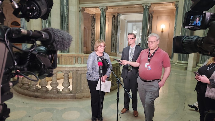 Alana Ross devant un micro au Palais législatif.