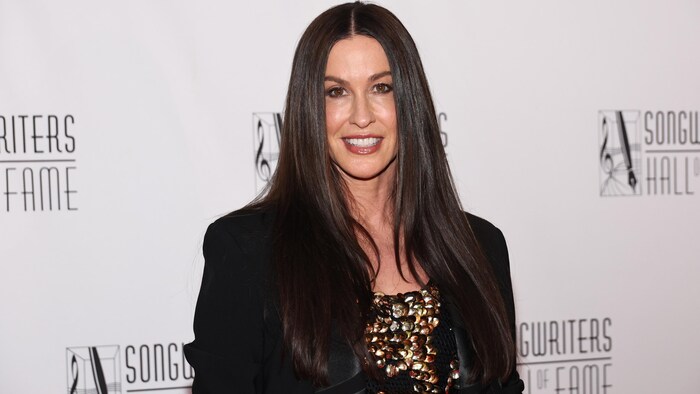 La chanteuse sourit sur le tapis rouge.