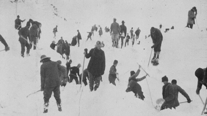 Photo d'archives d'avril 1898, qui montrent des dizaines d'hommes cherchant les corps ensevelis sous la neige.   