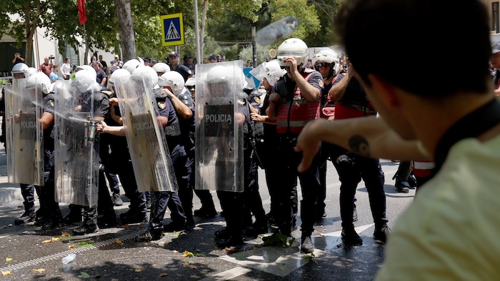 Un manifestant lance des pierres alors que de violents affrontements ont éclaté entre la police et les manifestants en marge d'une manifestation devant le Parlement, à Tirana, le 2 juillet 2026. 