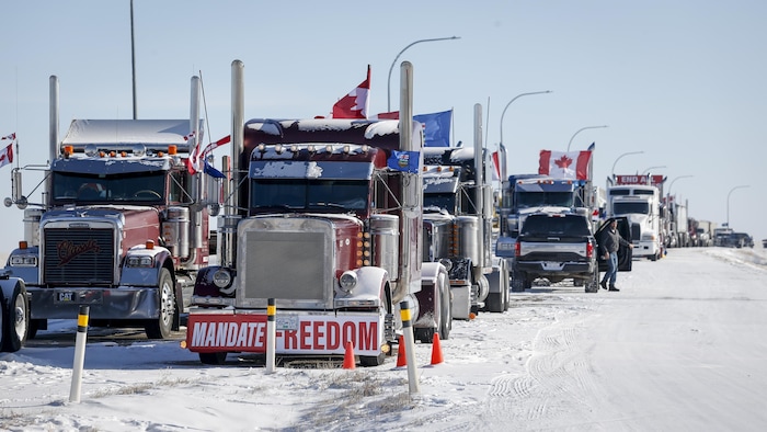 Des camions bloquent l'autoroute au passage frontalier vers les États-Unis de Coutts, en Alberta, le mercredi 2 février 2022. 