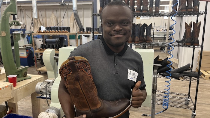 Un homme qui tient une botte.