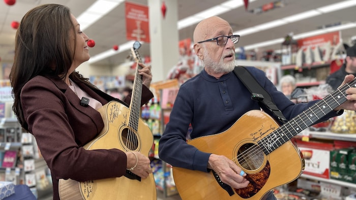 Nathalie Lord et Patrick Norman chantent une chanson à la guitare.