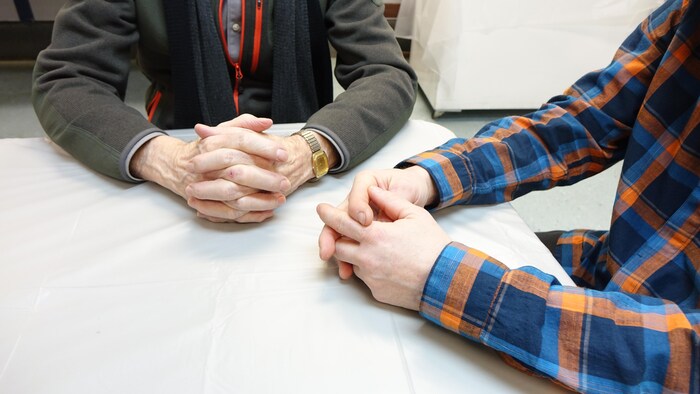 Les mains de deux hommes posées sur une table