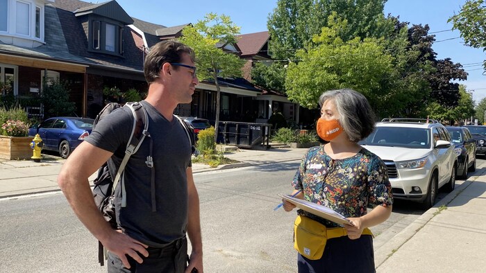 Alejandra Bravo parle à un résident du district de Davenport lors d'une de ses marches de campagne où elle fait du porte-à-porte pour parler aux électeurs.