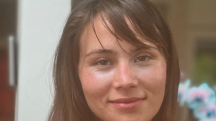 Une femme portant une camisole, les cheveux bruns avec une frange.