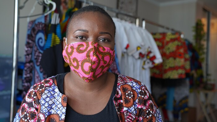 Une femme avec un masque coloré sur le visage.