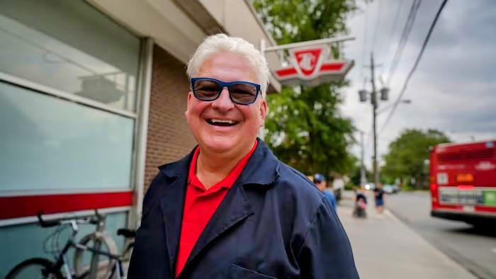 Alex Crawford devant une affiche de la Commission de transport de Toronto.